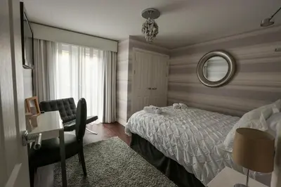 a bedroom with a bed and a desk and a mirror at Viewpoint Villa - Luxury 4 Bedroom villa with elevated views in Rothesay