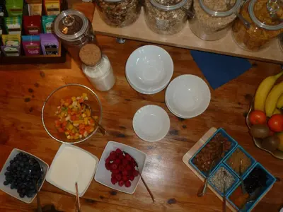 a wooden table topped with bowls of fruits and vegetables at Failte Bed & Breakfast in Oban