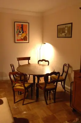 a dining room table with chairs and a lamp at Butlers Quarters Apartment in Cairndow