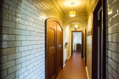a hallway of a building with a door and a brick wall at Butlers Quarters Apartment in Cairndow