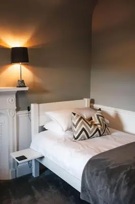 a bedroom with a white bed with a lamp on it at The Old School House, luxury home with hot tub. in Minnigaff