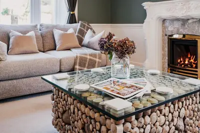 a living room with a couch and a coffee table at The Old School House, luxury home with hot tub. in Minnigaff