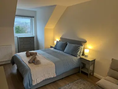 a bedroom with a bed with a teddy bear on it at Inchmurrin Townhouse, Loch Lomond in Bonhill