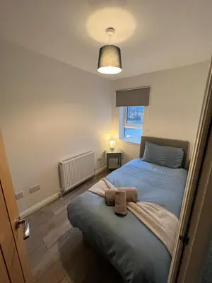 a small bedroom with two beds and a lamp at Inchmurrin Townhouse, Loch Lomond in Bonhill