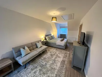 a living room with a couch and a bed at Inchcailloch Townhouse, Loch Lomond in Bonhill