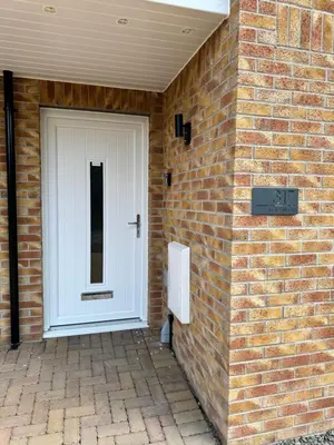 a white door on the side of a brick building at Inchcailloch Townhouse, Loch Lomond in Bonhill