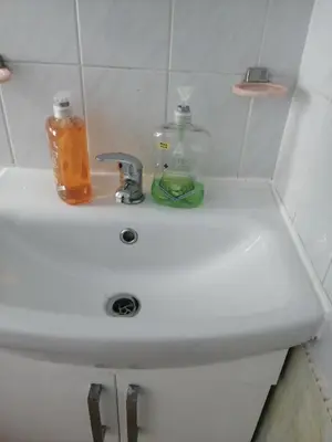 a bathroom sink with a soap dispenser on it at Comfortable Rooms With Work Desks In Cheerful Apartment Glasgow City in Glasgow