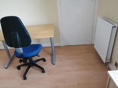 a blue office chair sitting next to a desk at Comfortable Rooms With Work Desks In Cheerful Apartment Glasgow City in Glasgow