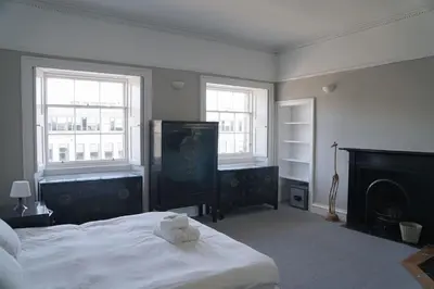 a bedroom with a white bed and two windows at Prime Edinburgh City Centre - 4 Bed Penthouse in Edinburgh
