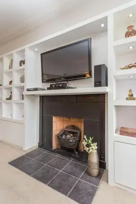 a living room with a fireplace with a flat screen tv at Prime Edinburgh City Centre - 4 Bed Penthouse in Edinburgh