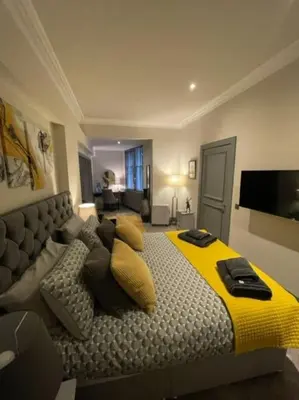 a bedroom with a large bed with a yellow blanket at Complete City Centre Comfort in Edinburgh