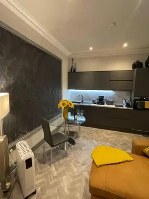 a room with a bed and a table and a kitchen at Complete City Centre Comfort in Edinburgh
