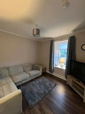 a living room with a couch and a television at Newly refurbished flat - Callander in Callander