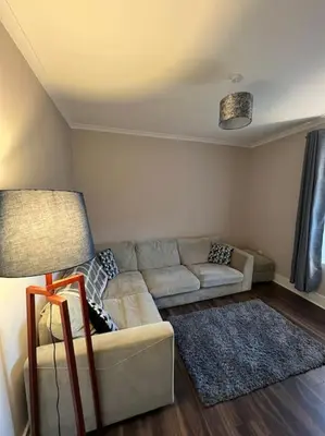 a living room with a couch and a lamp at Newly refurbished flat - Callander in Callander