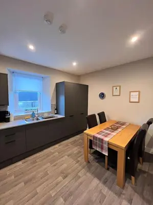 a kitchen with a wooden table and a table and chairs at Newly refurbished flat - Callander in Callander