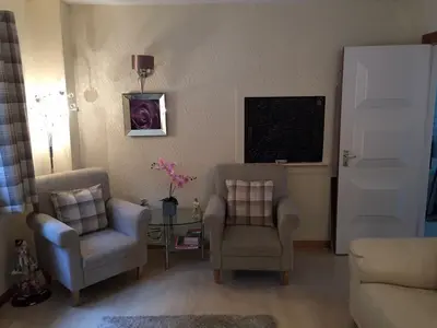 a living room with two chairs and a table at Southfork Villa Guesthouse in Callander