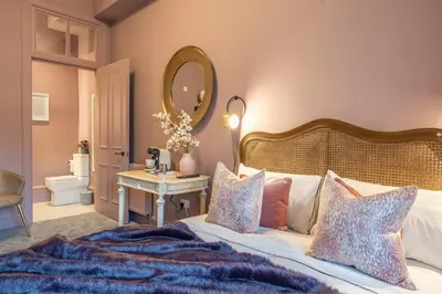 a bedroom with a large bed and a mirror at Boutique Home Stay Blossom in Paisley