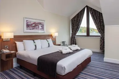 a hotel room with a bed with two stuffed animals on it at Holiday Inn Glasgow - East Kilbride by IHG in East Kilbride