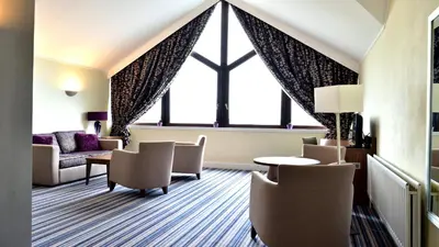 a hotel room with chairs and a table and a window at Holiday Inn Glasgow - East Kilbride by IHG in East Kilbride