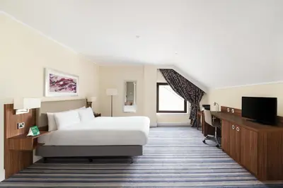 a hotel room with a bed and a flat screen tv at Holiday Inn Glasgow - East Kilbride by IHG in East Kilbride