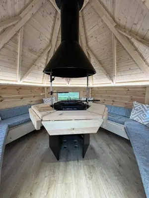 a room with a stove in a sauna at Capledrae Farmstay Shepherds Huts in Cardenden
