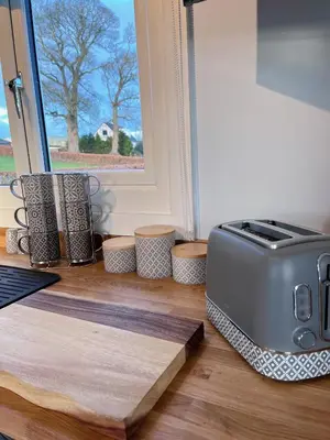 a toaster sitting on the floor next to a window at Capledrae Farmstay Shepherds Huts in Cardenden