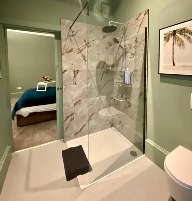 a bathroom with a shower with a toilet and a bed at Boutique Home Stay - Bliss Studio in Paisley