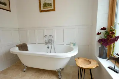 a white bath tub in a white bathroom at The Lodge at Carrick Castle Estate in Cairndow