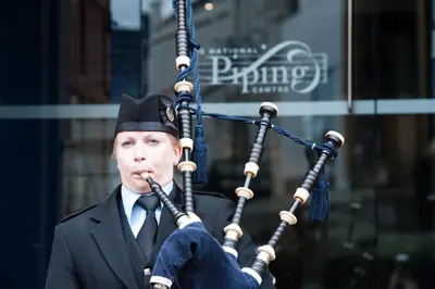 a man in a suit playing a bagpipe at The Pipers' Tryst Hotel in Glasgow