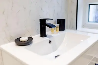 a bathroom sink with a black faucet at Welcoming Home in Johnstone, Near Glasgow Airport - Bonnie Lodgings in Johnstone