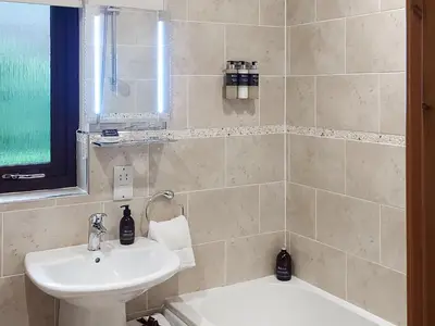 a bathroom with a sink and a toilet and a tub at Roe Deer Cottage in North Ballachulish