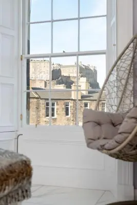 a room with a window with a view of a city at Spacious modern city centre apartment Castle Views in Edinburgh
