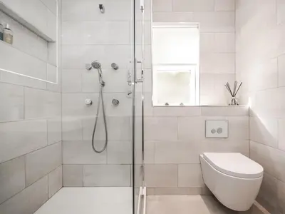 a white bathroom with a shower and a toilet at The White House in Callander