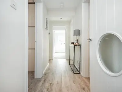 a white bathroom with a urinal and a hallway at The White House in Callander
