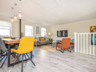 a living room with yellow chairs and a table at The White House in Callander