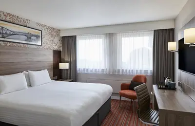 a hotel room with a large bed and a desk at Leonardo Edinburgh Murrayfield in Edinburgh