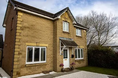 a brick house with a white door at Harvest House with Games Room in Stirling