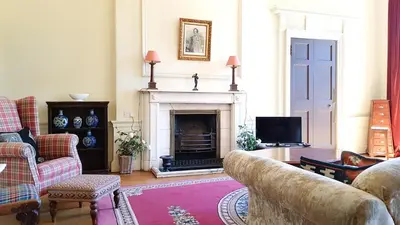 a living room with a couch and a fireplace at Spacious 2-Bedroom Georgian Edinburgh City Apartment in Edinburgh