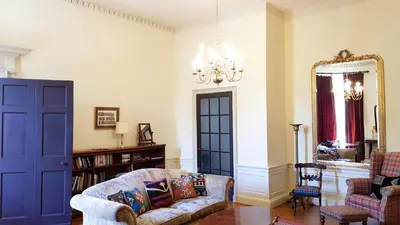 a living room with a couch and a mirror at Spacious 2-Bedroom Georgian Edinburgh City Apartment in Edinburgh
