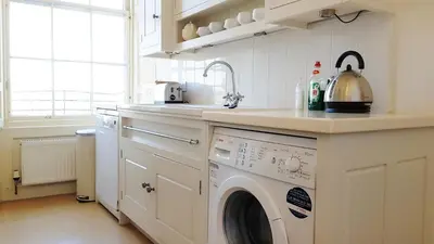 a kitchen with a washing machine and a sink at Spacious 2-Bedroom Georgian Edinburgh City Apartment in Edinburgh