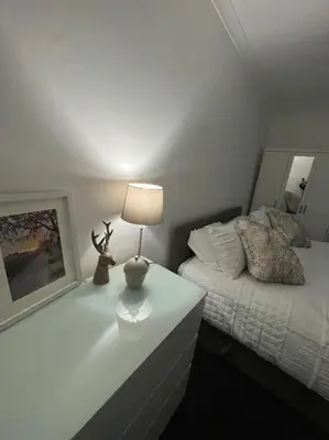 a bedroom with a bed and a lamp on a table at Albert House in Airdrie