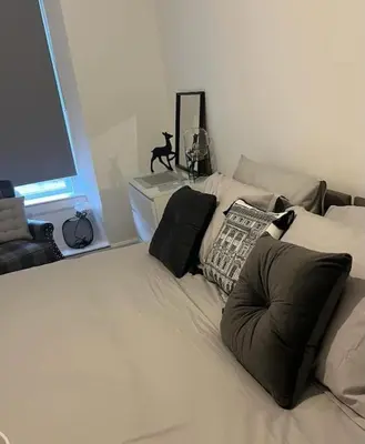 a white bed with pillows on it in a room at Albert House in Airdrie