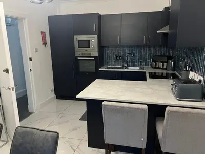 a kitchen with black cabinets and a counter top at Albert House in Airdrie