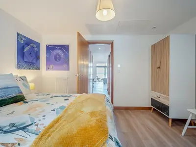 a bedroom with a large bed and a closet at Postbox Cottage in Lochranza