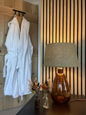 a lamp on a table with towels on a wall at 2 bed lodge with private hot tub in Aviemore in Saint Ninians