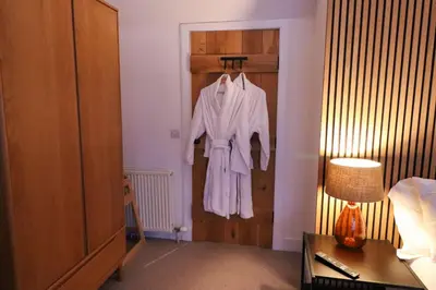 a hotel room with a robe hanging on a door at 2 bed lodge with private hot tub in Aviemore in Saint Ninians
