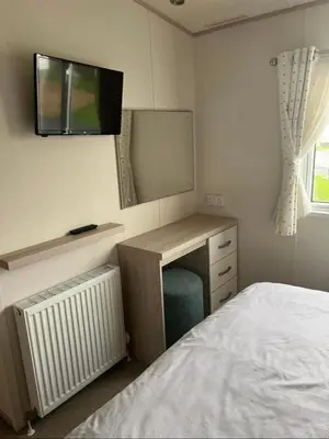 a bedroom with a bed and a desk with a television at GDs Luxury Caravan Hire Turnberry Holiday Park in Turnberry