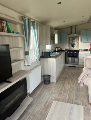 a kitchen with a living room with a tv and a couch at GDs Luxury Caravan Hire Turnberry Holiday Park in Turnberry