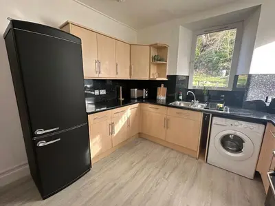 a kitchen with a black refrigerator and a dishwasher at Combie Lane Apartments in Oban