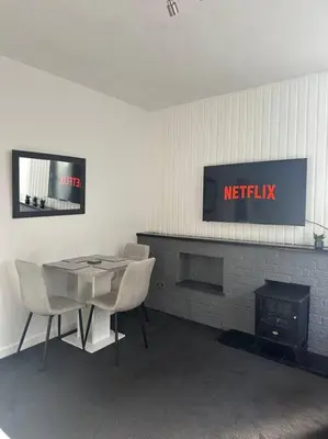 a room with a table and chairs and a fire place at Combie Lane Apartments in Oban